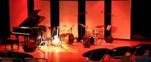 Alvas Show Room in San Pedro with brightly colorful stage with instruments set out: piano, guitar, drums.