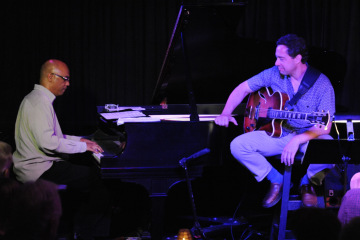 photo of Larry Koonse playing guitar on stage playing harp