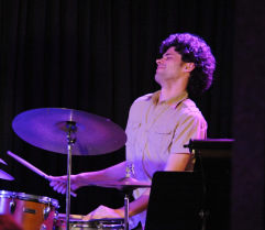 David Schnell playing drums on stage.