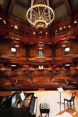 Sanders Theatre at Harvard University, view from stage showing piano in foreground and tiers of theater seating.