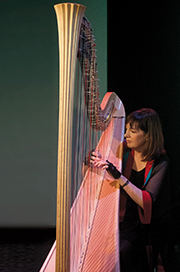 photo of Carol Robbins playing harp on stage