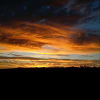 photo of very dark and moody sunset over dark landscape