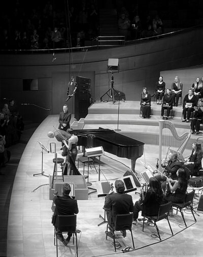 Billy childs takes a bow on stage at walt disney concert hall november nineteenth, twenty-twenty-three. Larry koonse and carol robbins look on, along with conductor grant gershon and violinist anne akiko meyers.